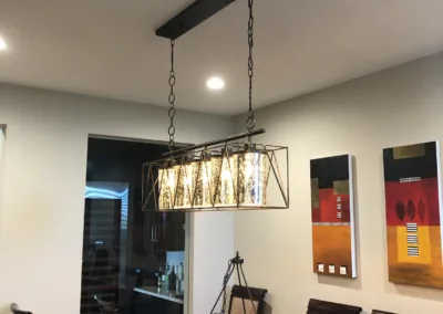 A dining room with a chandelier hanging over the table.