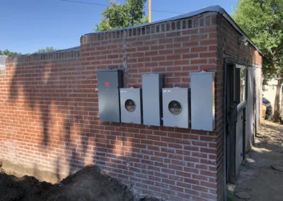 A red brick building with several electrical boxes on it.