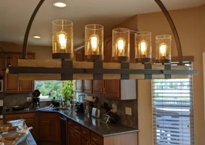 A kitchen with a wooden floor and a light fixture.